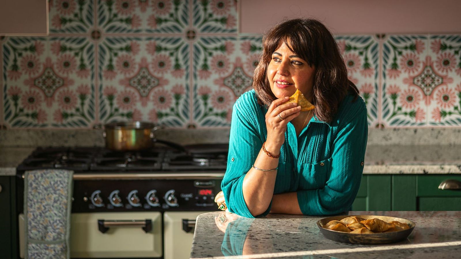 Chef Romy Gill holding a samosa